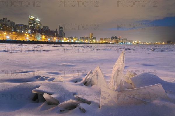 Ukraine, Dnepropetrovsk region, Dnepropetrovsk city, Frozen river with distant city skyline at night