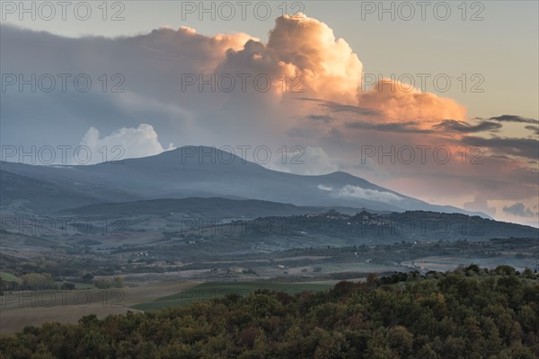 Italy, Tuscany, San Quirico D'orcia, Landscape in evening with flaming clouds in sky