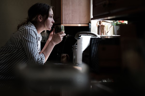 Woman looking through kitchen window