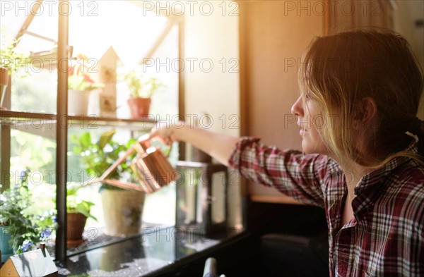 Woman watering plants at home