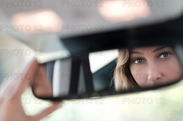 Woman face reflected in rearview mirror