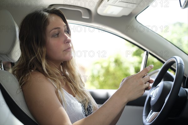 Woman using smartphone in car