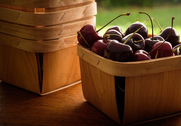 Basket full of cherries on wooden table