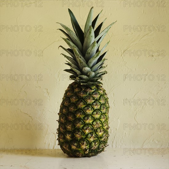 Fresh pineapple against textured wall
