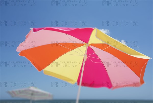 Colorful beach umbrella against blue sky