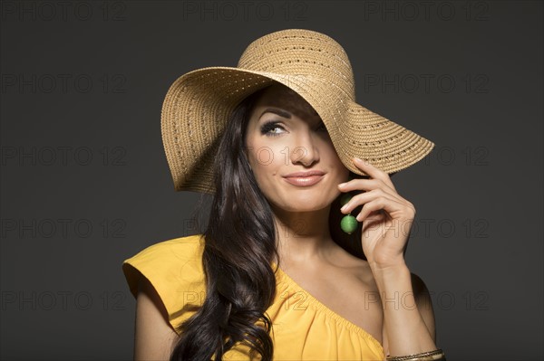 Portrait of woman wearing straw hat and yellow top
