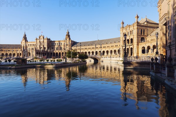 Spain, Andalusia, Seville, Plaza de Espana reflecting in water surface
