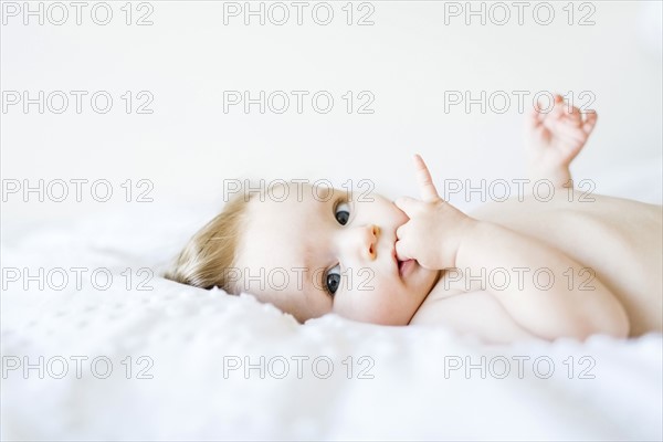 Portrait of baby girl (6-11 Months) with finger in mouth