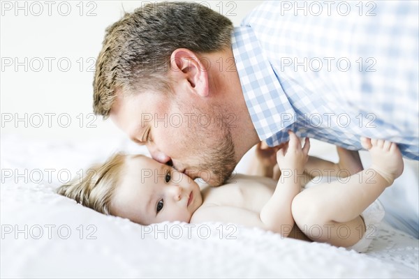 Baby girl (6-11 Months) being kissed by father