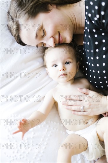 Baby girl (6-11 Months) being hugged by mother, directly above