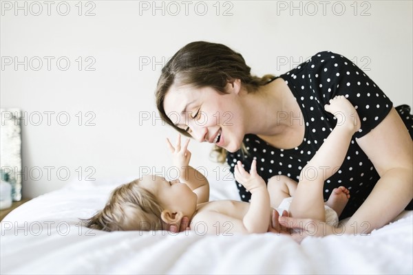 Baby girl (6-11 Months) playing with mother