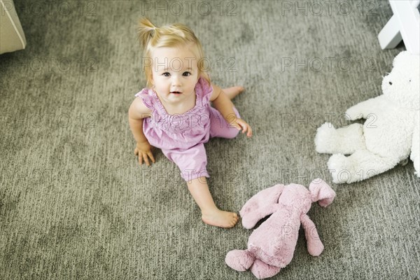 Portrait of baby girl (12-17 months) sitting on floor