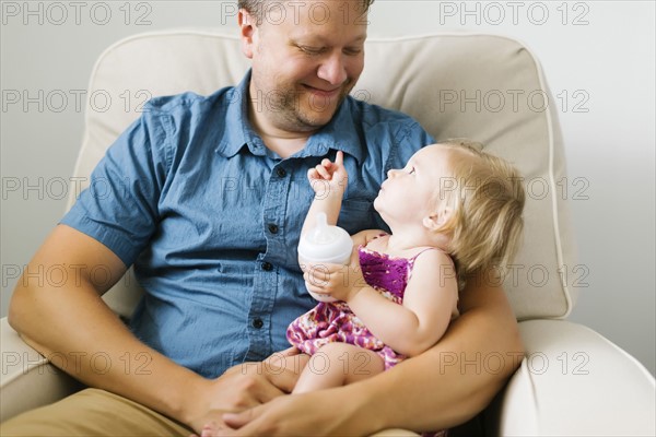 Father feeding baby girl (12-17 months)