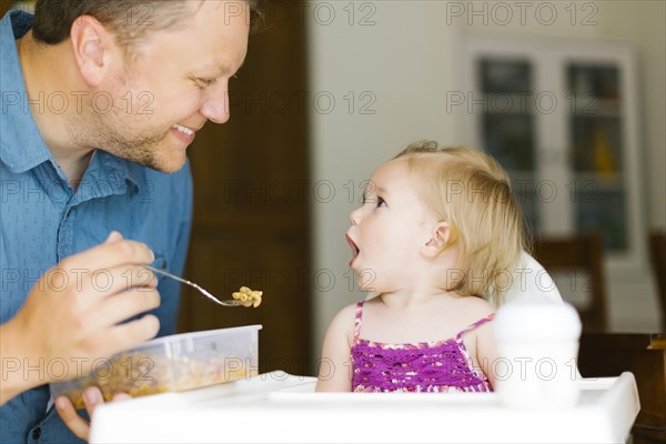 Father feeding baby girl (12-17 months)