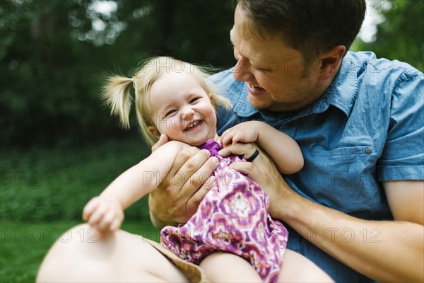 Father playing with baby girl (12-17 months) in backyard