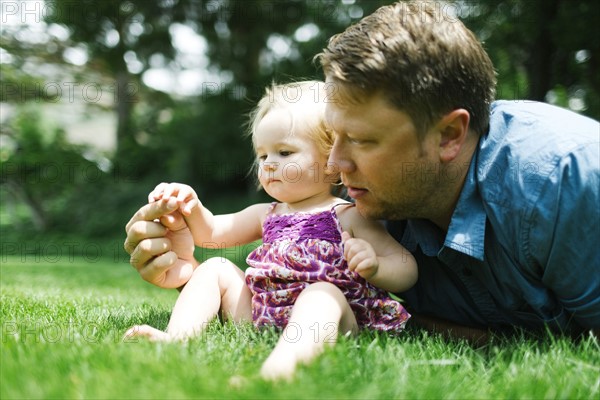 Father playing with baby girl (12-17 months) in backyard