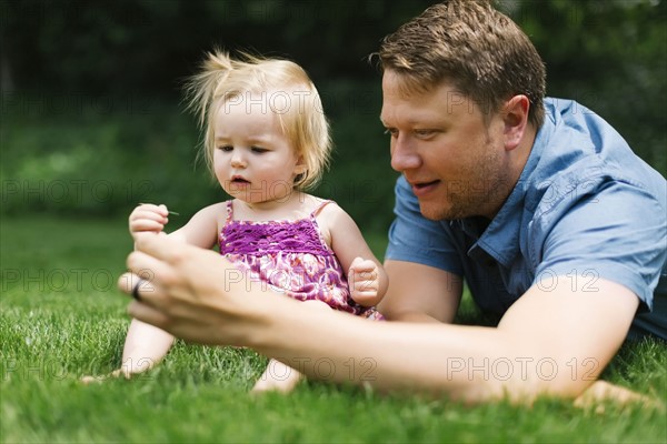 Father playing with baby girl (12-17 months) in backyard