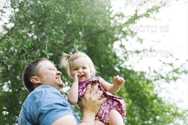 Father playing with baby girl (12-17 months) in backyard