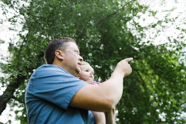 Father playing with baby girl (12-17 months) in backyard