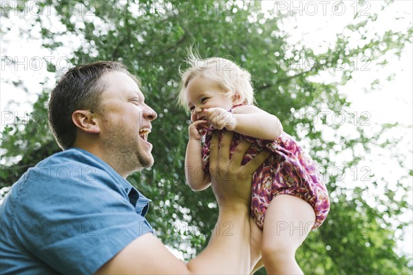 Father playing with baby girl (12-17 months) in backyard