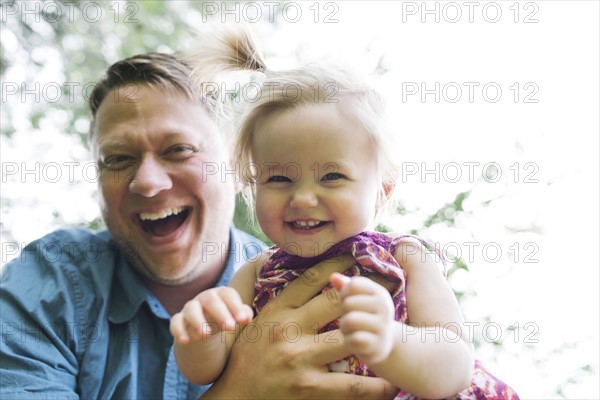 Father playing with baby girl (12-17 months) in backyard