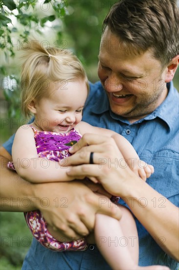 Father playing with baby girl (12-17 months) in backyard