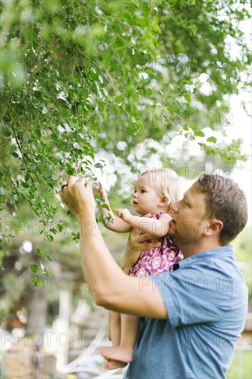 Father playing with baby girl (12-17 months) in backyard