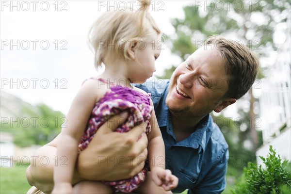 Father playing with baby girl (12-17 months) in backyard