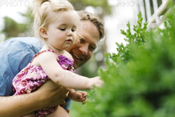 Father playing with baby girl (12-17 months) in backyard