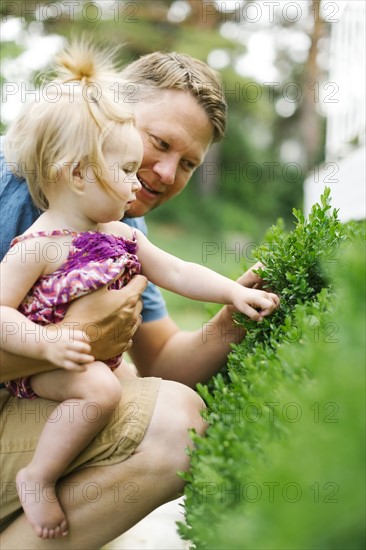 Father playing with baby girl (12-17 months) in backyard