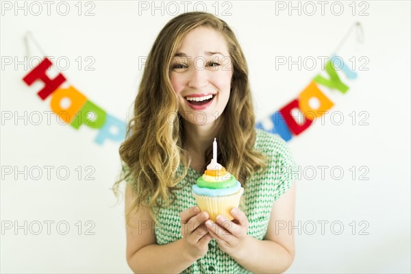 Mid adult woman blowing birthday candle