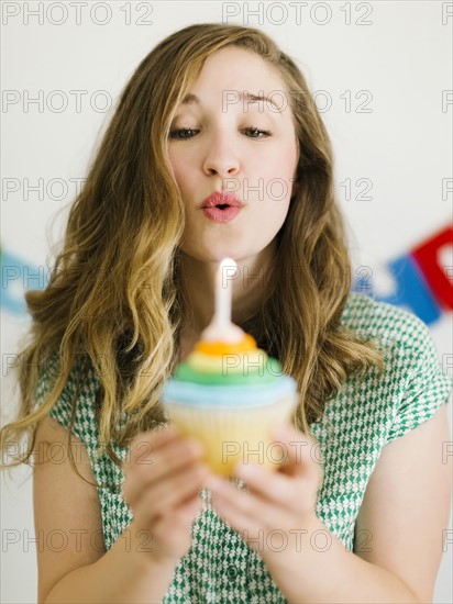 Mid adult woman blowing birthday candle