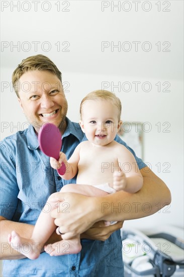 Portrait of father and baby girl (12-17 months) after bath