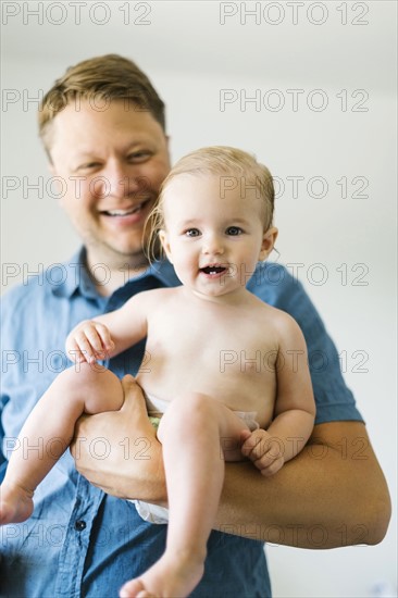 Portrait of father and baby girl (12-17 months) after bath