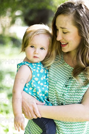 Portrait of mother and baby girl (12-17 months) in backyard