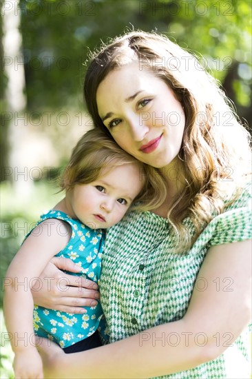 Portrait of mother and baby girl (12-17 months) in backyard