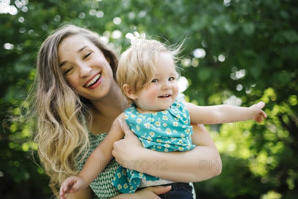 Portrait of mother carrying daughter (12-17 months)