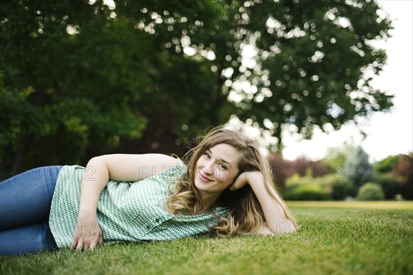 Portrait of woman lying on grass