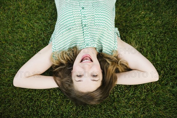 Portrait of woman lying on grass and laughing