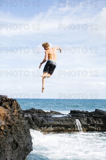 Young man jumping into sea