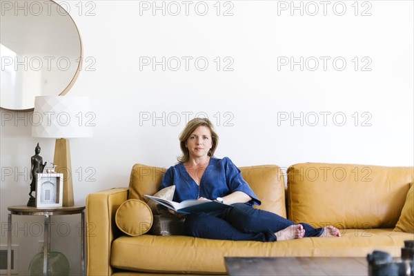 Woman sitting on sofa in living room