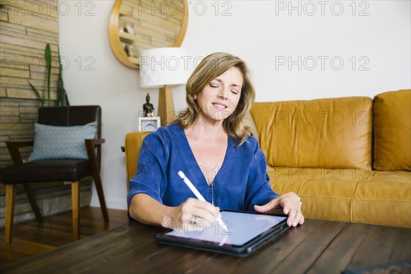 Woman using digital tablet in living room