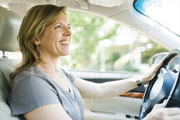 Smiling woman driving car