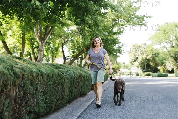 Woman walking with Labrador Retriever