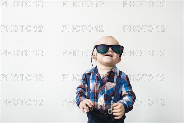 Studio shot of baby boy (12-17 months) wearing sunglasses
