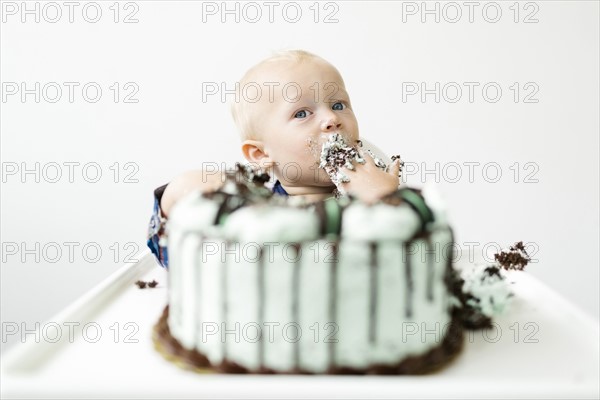 Baby boy (12-17 months) eating birthday cake