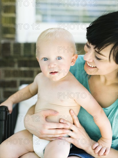 Mother sitting with baby boy (12-17 months) on porch