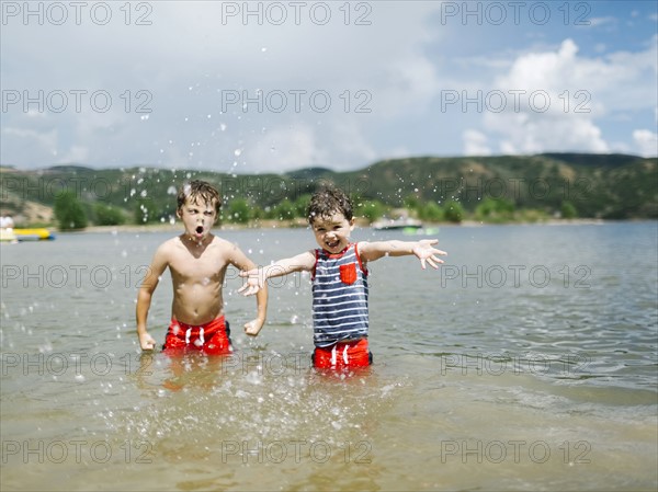 USA, Utah, Park City, Brothers (4-5, 6-7) playing in lake