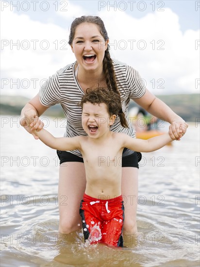 Mother playing with son (4-5) in lake