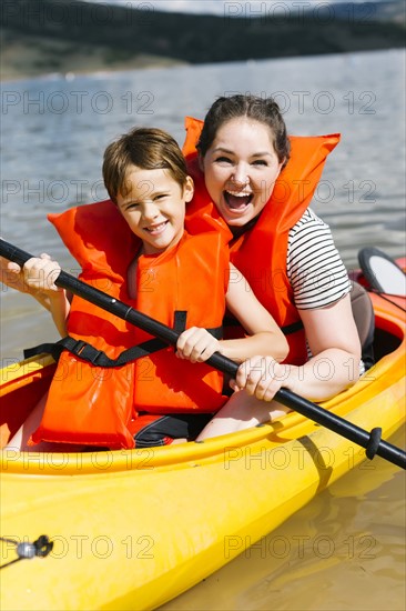 Mother with son (6-7) kayaking on lake